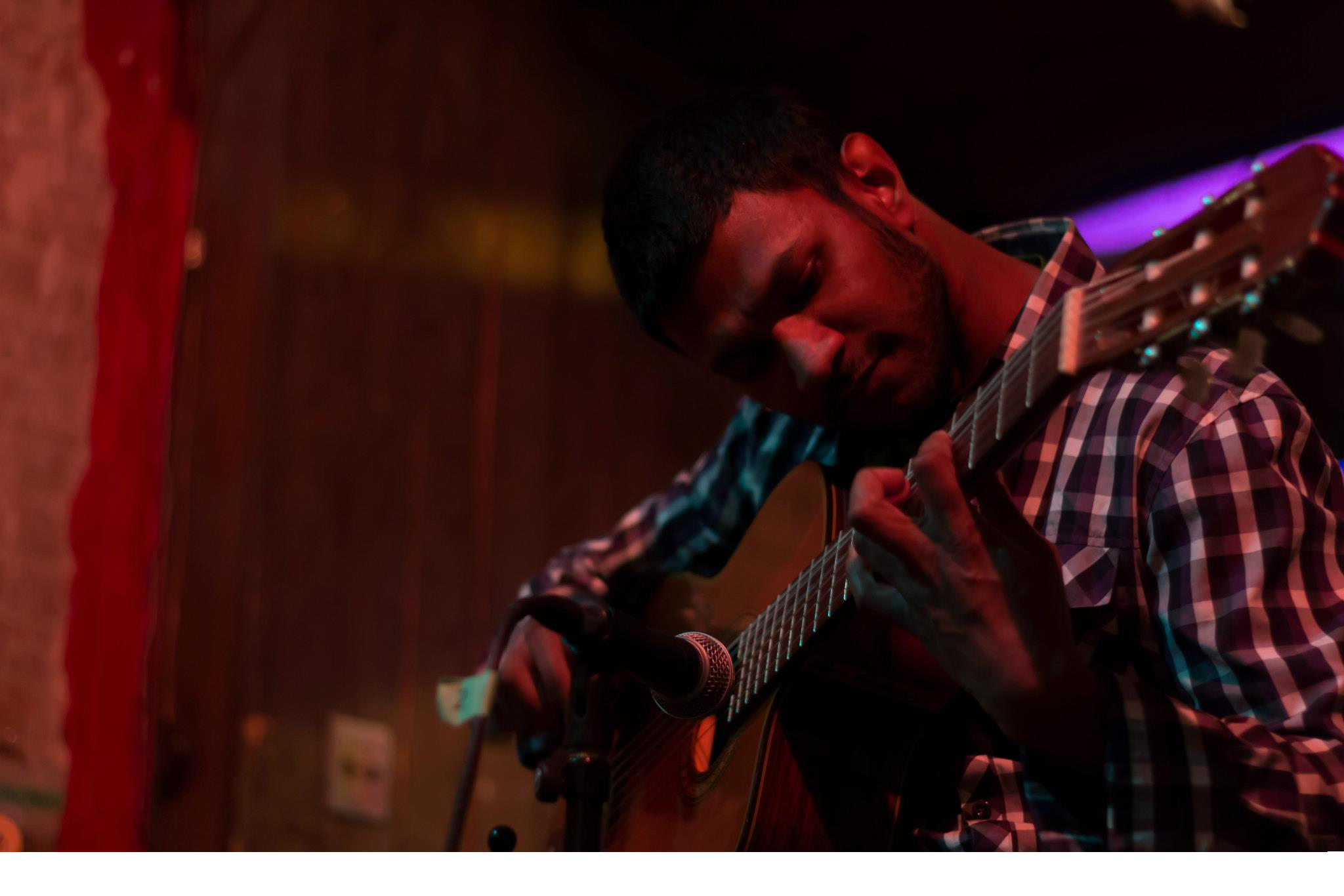 Man (Midian Judah) playing classical guitar.